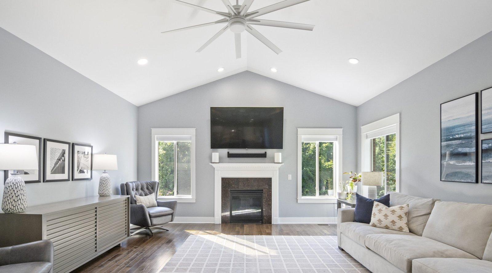 Bright living room with a vaulted ceiling, fireplace and sofa, photographed by Leverage Real Estate Photography